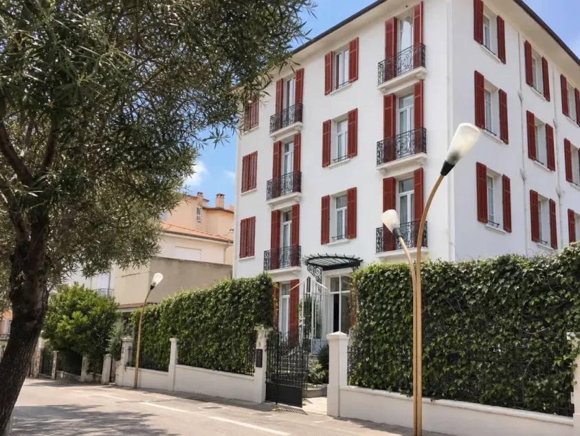 Façade aux volets rouges de l’Hôtel Cecil à Juan-les-Pins